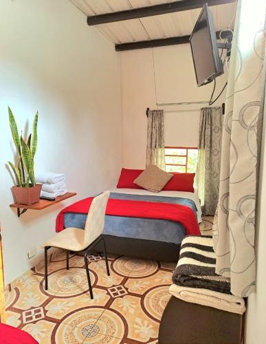a bedroom with a bed and a flat screen tv at Hotel Marrokos Aeropuerto José María Córdova in Rionegro
