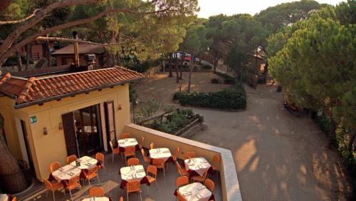 a restaurant with tables and chairs on a balcony at Camping Lacona Pineta in Capoliveri
