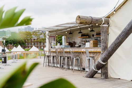 a bar on a deck with bar stools at Collective Retreats Governors Island in New York