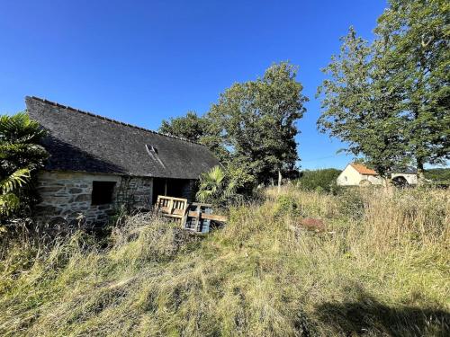an old stone house on a grassy hill at Menhirs et Moutons Ouessant in Plouëc-du-Trieux