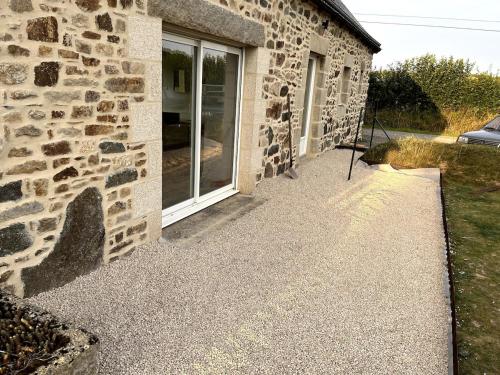 a stone building with a window on the side of it at Menhirs et Moutons Ouessant in Plouëc-du-Trieux