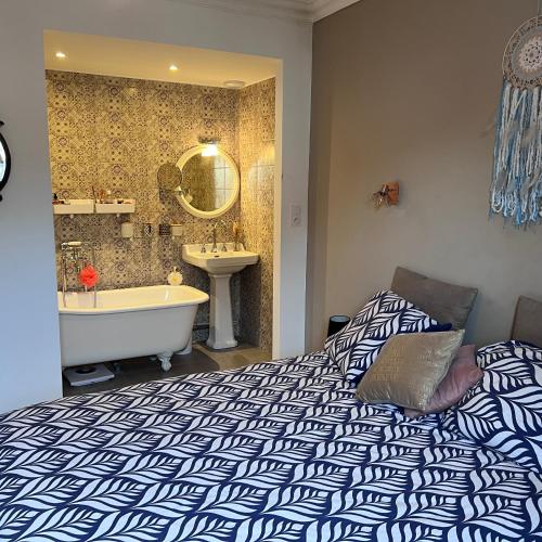 une chambre avec un lit, une baignoire et un lavabo dans l'établissement Lna, à La Celle-sous-Gouzon