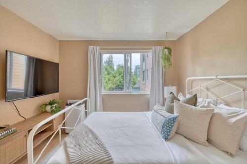 a bedroom with a white bed and a window at Stay Portland - Adorable Bright 1 Bed Near OHSU in Portland