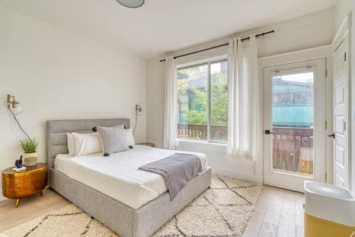a white bedroom with a bed and two windows at Stay Portland - Perfect Portland Farmhouse Loft - Breweries & Bars in Portland