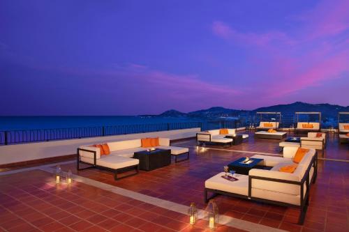 a rooftop deck with couches and tables at night at Krystal Grand Los Cabos - All Inclusive in San José del Cabo