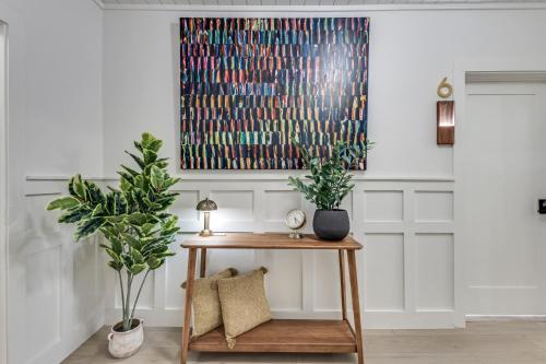a living room with a table and a painting on the wall at The Vanderbilt Mansion Apt 7 Near Downtown and TWU in Denton