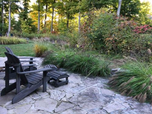 a park bench and a chair in a garden at The Chorus Frog - 8 Hollow in Cherry Valley