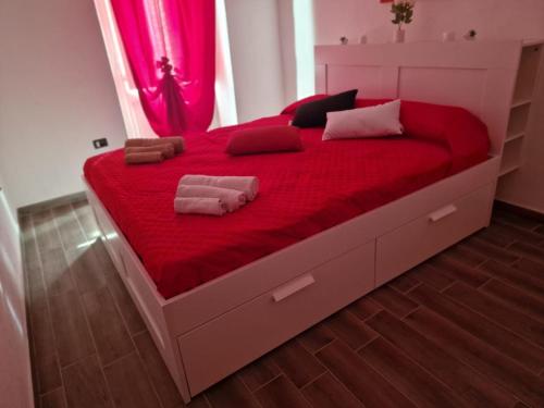 a bedroom with a large bed with red sheets at Case Vacanza Marganai in Iglesias