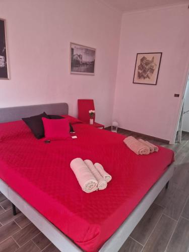 a large red bed with two towels on it at Case Vacanza Marganai in Iglesias