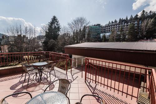 a patio with a table and chairs on a balcony at OSW Sportowiec in Krynica Zdrój