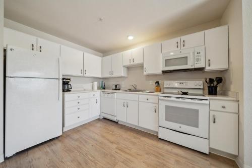 a kitchen with white appliances and white cabinets at Properties By Preston I 1bd1bth I Pool I Parking in San Antonio