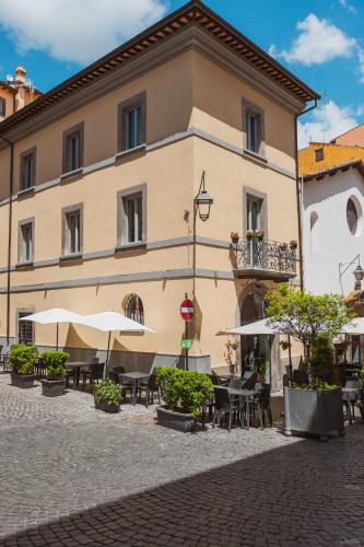 a building with tables and umbrellas in a courtyard at Palazzo San Biagio in Viterbo