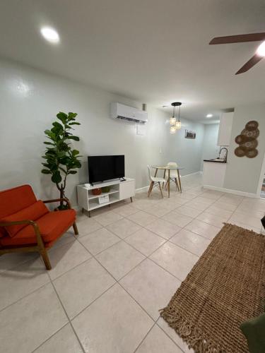 a living room with a tv and a couch and a table at VillaBellaWood in Fort Myers