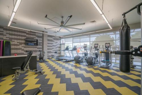a gym with treadmills and exercise equipment on a checkered floor at Modern 2BD DT - Balcony, Gym, W-D, Parking - Sleeps 8 in Phoenix