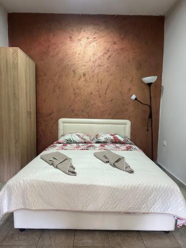 a bedroom with a bed with two slippers on it at Brioni in Virpazar