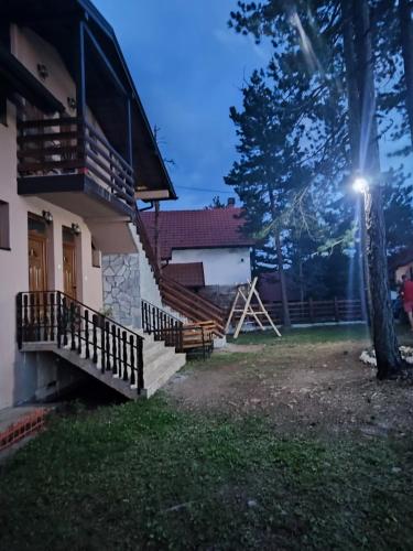 a house with a staircase and a tree and a light at Apartman Sofija in Kaludjerske Bare