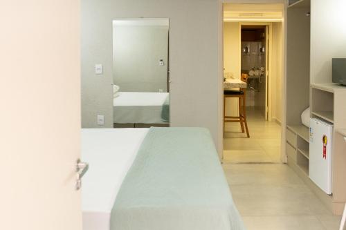 a bedroom with a bed and a bathroom at Hotel Municipal Araraquara in Araraquara