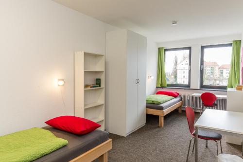 a bedroom with two beds and a table and chairs at Inselhostel in Lindau