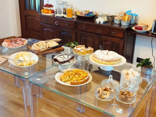 a table filled with different types of cakes and desserts at Agriturismo Ca' del Clat in Bagnolo Piemonte