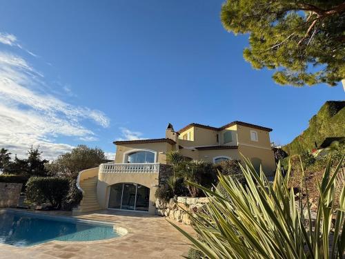 une grande maison avec une piscine devant dans l'établissement Villa Sud in Antibes mit Pool- Meer- und Alpenblick, à Antibes