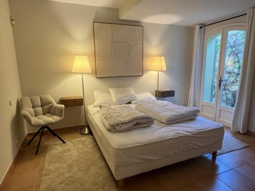 un lit dans une chambre avec une lampe et une chaise dans l'établissement Villa Sud in Antibes mit Pool- Meer- und Alpenblick, à Antibes