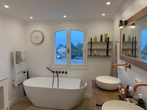 une salle de bain avec une grande baignoire et deux lavabos dans l'établissement Villa Sud in Antibes mit Pool- Meer- und Alpenblick, à Antibes