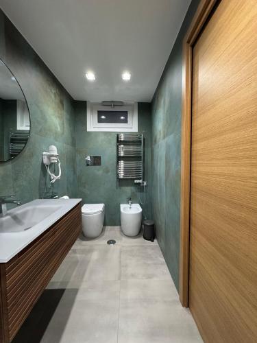 Un baño con lavabo, inodoro y espejo. en SOTTARCO B&Benevento, en Benevento