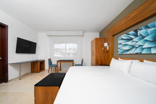 a hotel room with a large bed and a desk at Krystal Grand Los Cabos - All Inclusive in San José del Cabo