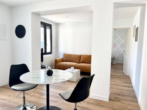 un salon avec une table, des chaises et un canapé dans l'établissement Le Hausmanien, à deux pas du port, au Tréport