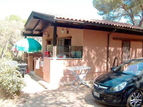 a car parked in front of a house at Camping Lacona Pineta in Capoliveri