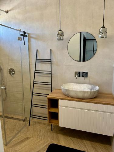 a bathroom with a sink and a mirror at Strefa Natur dom z jacuzzi na wyłączność in Matyty