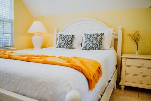a bedroom with a white bed with an orange blanket at Shangri-La Boutique Bed & Breakfast in West Bay