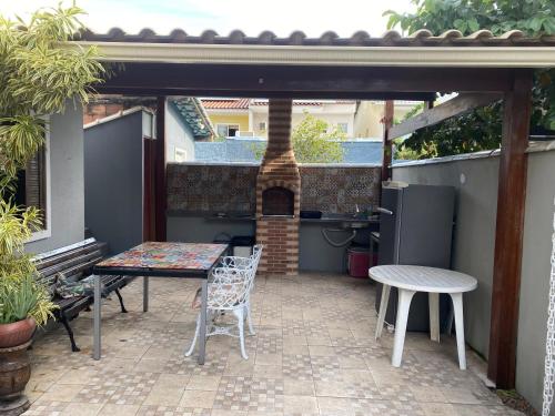 um pátio com mesa e cadeiras e uma churrasqueira em Casa 2 Suites, Niterói Região Oceanica em Niterói
