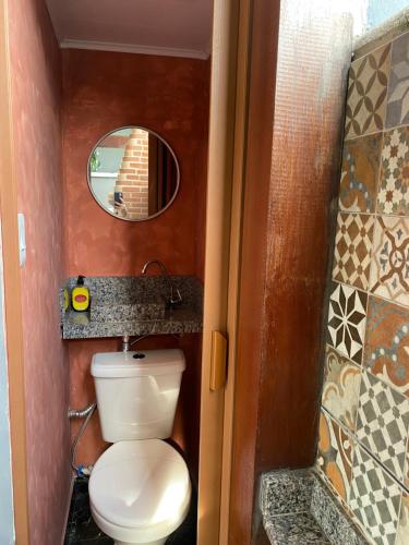 um pequeno banheiro com um vaso sanitário e um espelho em Casa 2 Suites, Niterói Região Oceanica em Niterói
