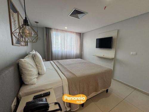 a hotel room with a bed and a television at IMPERIAL TAMBAU Flat by PenareiaTurBr in João Pessoa