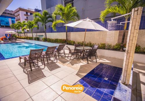 a patio with a table and chairs next to a pool at IMPERIAL TAMBAU Flat by PenareiaTurBr in João Pessoa