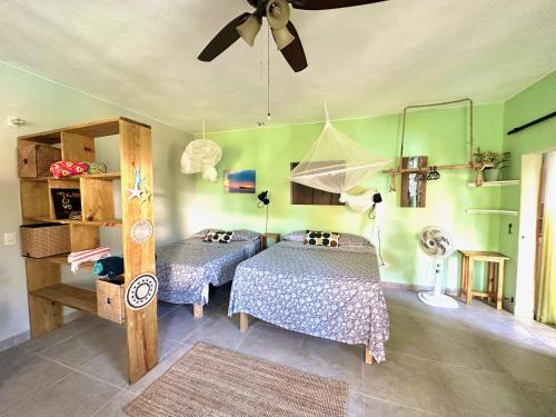 a room with two beds and a ceiling fan at Cabarete Boutique Kite Hotel Garden Loft in Cabarete