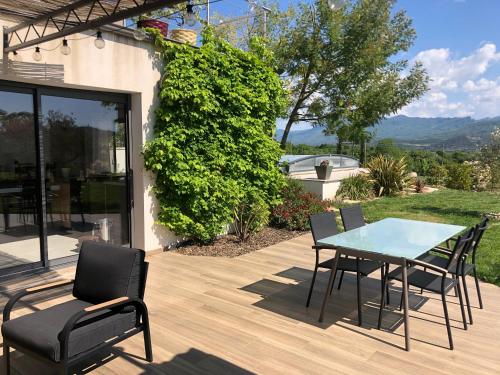 a patio with a table and chairs on a deck at Studio Mimosa in Crest