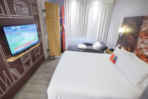 a hotel room with a bed and a flat screen tv at ibis Quito in Quito