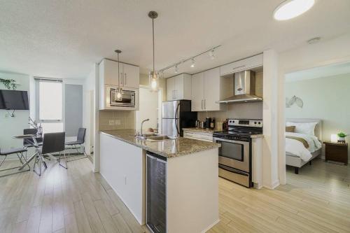 a kitchen and living room with a bed in a room at Gorgeous Water View Unit in Downtown Vancouver in Vancouver