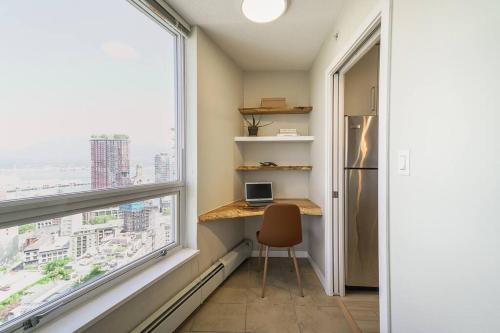 a small desk in a room with a large window at Gorgeous Water View Unit in Downtown Vancouver in Vancouver
