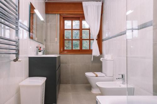 un bagno con un water, un lavandino e una finestra di Entorno rural con piscina by CABANA Rentals a Budiño