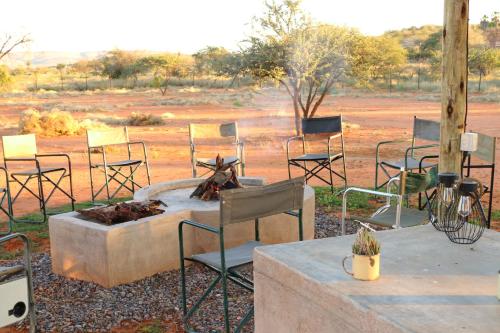 a group of chairs sitting around a fire pit at Orpheus Inn Camping in Kaneb Pos