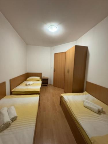 a room with three beds and a cabinet in it at Apartments Vidikovac in Međugorje