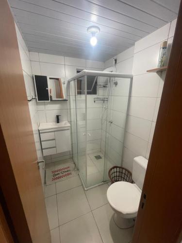 a bathroom with a glass shower and a toilet at Apartamento térreo de 1 quarto próximo a Arena Opus in São José