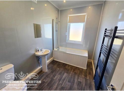 a bathroom with a sink and a toilet and a tub at Manchester St by Prestige Properties SA in Barrow in Furness