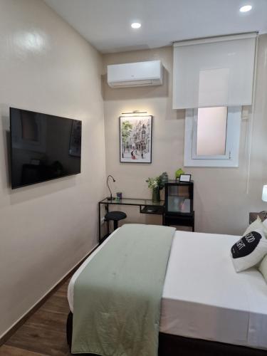 a bedroom with a bed and a flat screen tv at Front Arc in Barcelona
