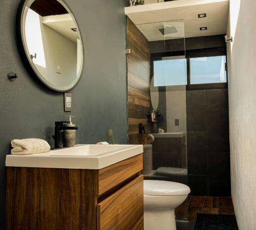 a bathroom with a sink and a toilet and a mirror at Garden Suite in Valle de Bravo
