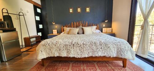 a bedroom with a large bed with a white comforter at Garden Suite in Valle de Bravo