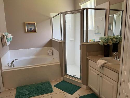 a bathroom with a tub and a shower and a sink at Home Away From Home in Kissimmee